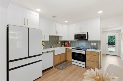 Modern kitchen with white cabinets and wood accents.