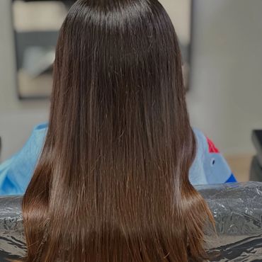 Smooth, straight, and shiny brown hair from the back.