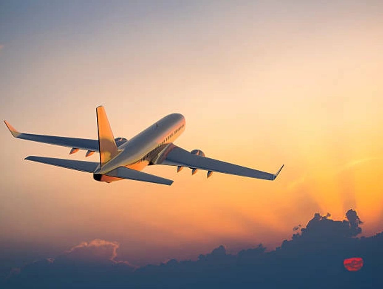 Airplane flying during a colorful sunset.