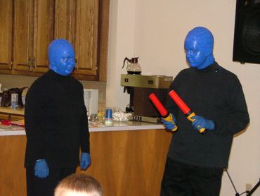 2 blue men at a wedding reception with wands