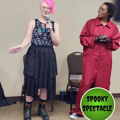 pink hair jen dressed in black stands next to an african american woman dressed in cosplay as US
