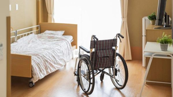 Empty wheelchair in a cozy bedroom.