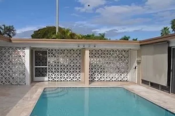 Outdoor swimming pool with geometric patterned walls.
