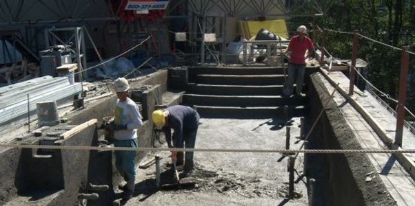 SLI Shotcrete workers finishing smoothing out concrete on a commerical pool.