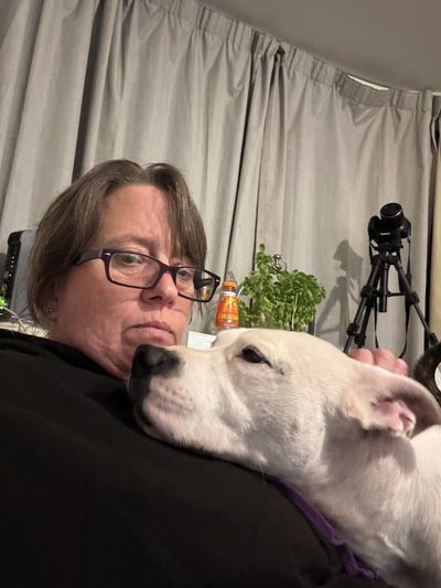 Ange sat cuddling watching tv with a staff bull terrier dog
