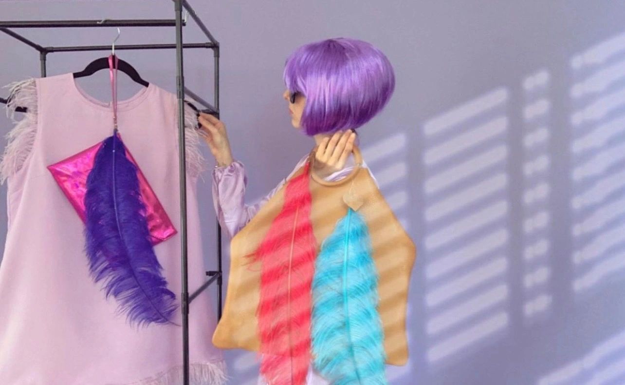 <alt> La Bendecida posa junto a una gran iluminación y sus piezas de arte </alt>