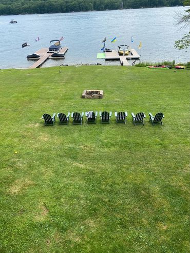 Chairs lined up facing a lake with docks and boats in the background.