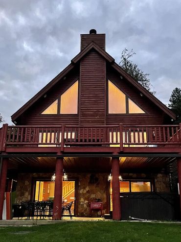 Cozy wooden cabin with warm glowing windows at dusk.