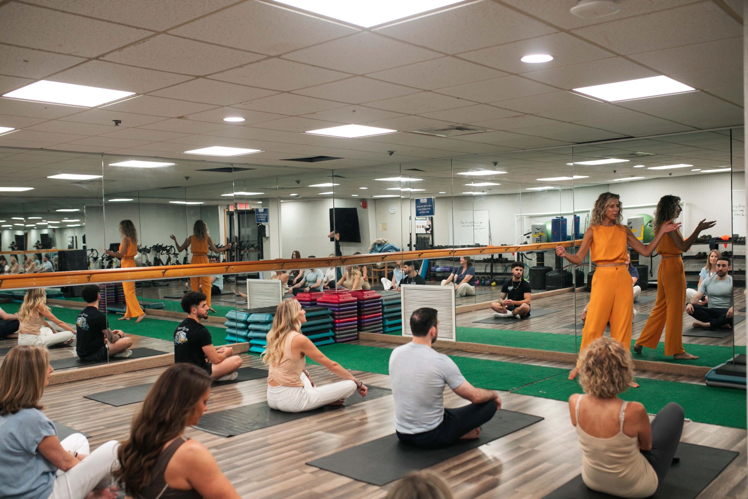 Yoga instructor teaching a meditation class in a studio.