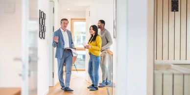 A real estate agent showing a couple a home interior.