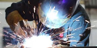 Welder working with sparks flying around.