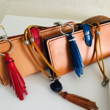 Ladies leather wallets made with a natural tan leather exterior with red interior or blue interior.