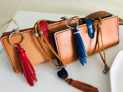 The Charlotte ladies leather wallet, with red and blue leather tassels and a custom ladies leather necklace.