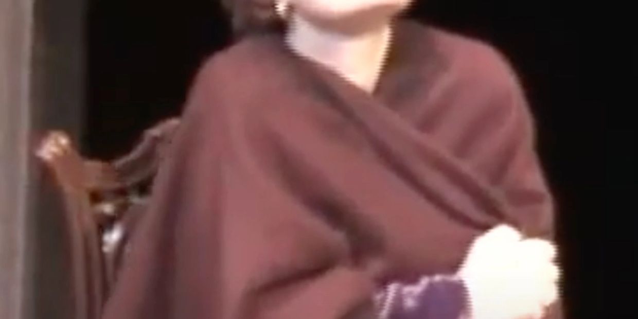 Person wrapped in a brown blanket or shawl.