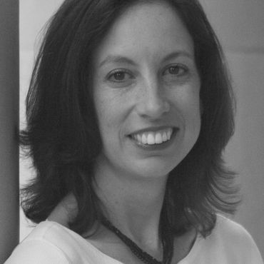 Black and white portrait of a woman smiling gently.