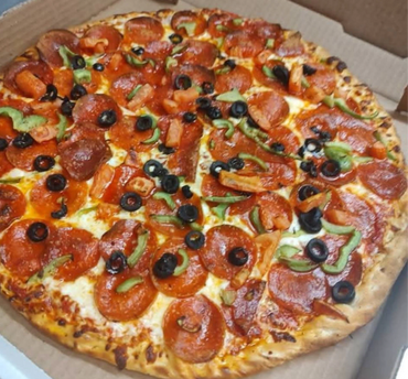 Pepperoni pizza with olives, green peppers, and tomatoes in a box.