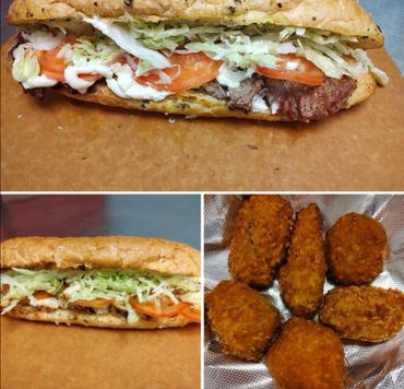 Two deli sandwiches with lettuce, tomato, and mayo, plus six crispy fried chicken wings.