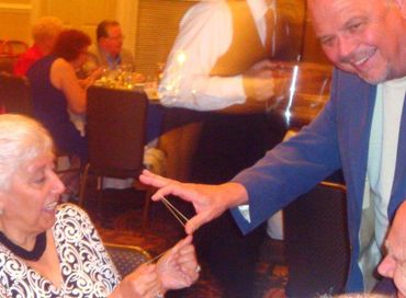 Mr. G The Magician performing rubber band magic at a corporate party in Jacksonville, Fl.