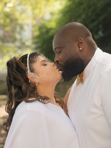 Couple sharing a tender kiss on their wedding day.