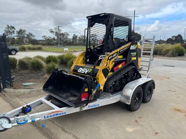 A compact ASV RT-40 tracked loader on a LoadMaxx trailer outdoors.