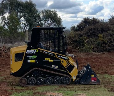 Yellow and black ASV RT-40 compact track loader on a dirt field.