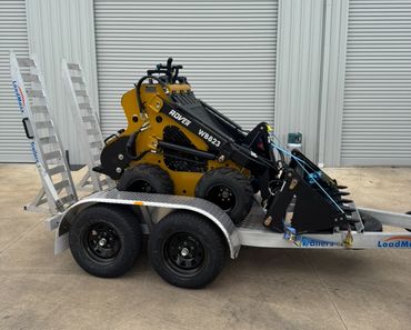 Compact Rover WB823 skid steer loader on a LoadMaxx trailer.