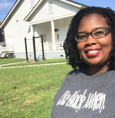 Melissa Stuckey standing in front of Rosenwald school building at Elizabeth City State University.