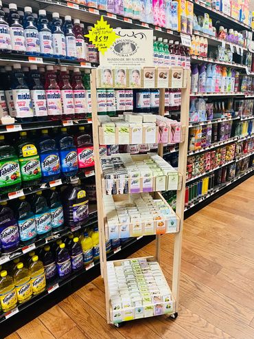 Display stand of natural handmade soaps in a store aisle.