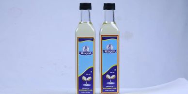 Two bottles of coconut oil with blue labels on a white surface.