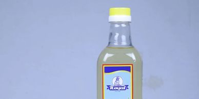 A clear plastic bottle with a yellow cap and a Royal label filled with liquid.