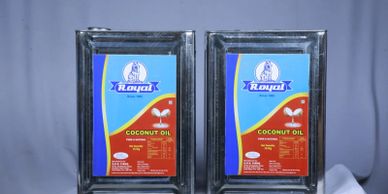 Two metal containers of Royal brand coconut oil with blue and red labels.