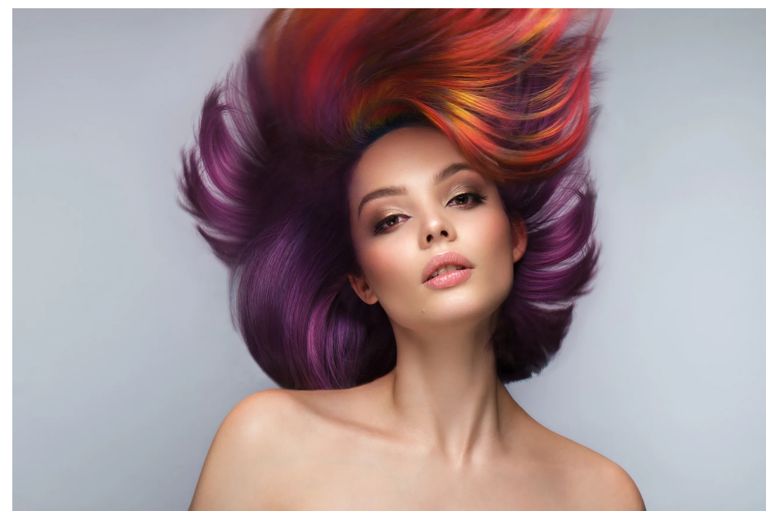 Woman with vibrant purple and fiery red-orange hair flowing dynamically.