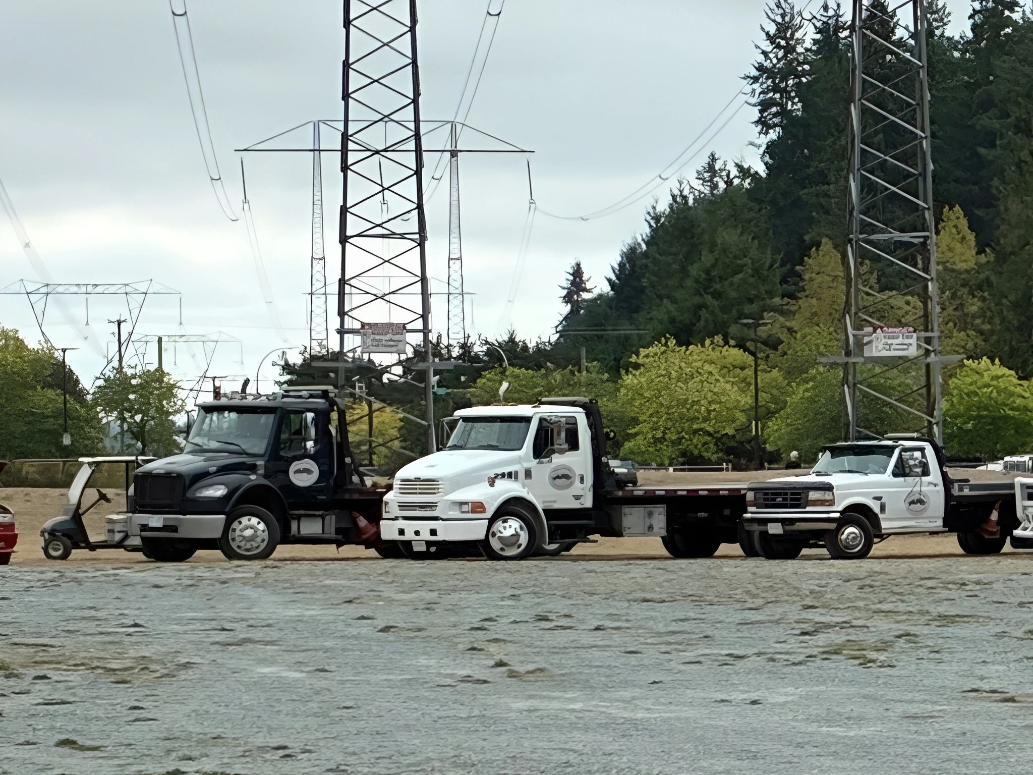Three tow trucks parked outdoors