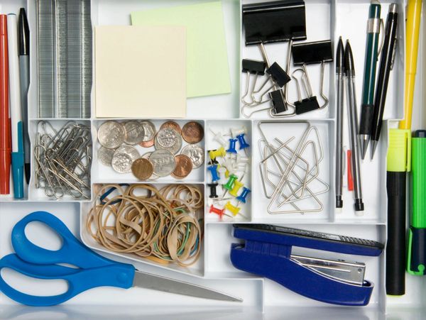 drawer with paper plips, pens, rubber band, coins, scissors