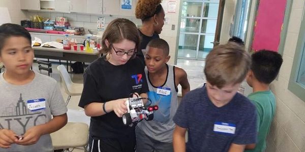 Children engaged in a robotics activity indoors.