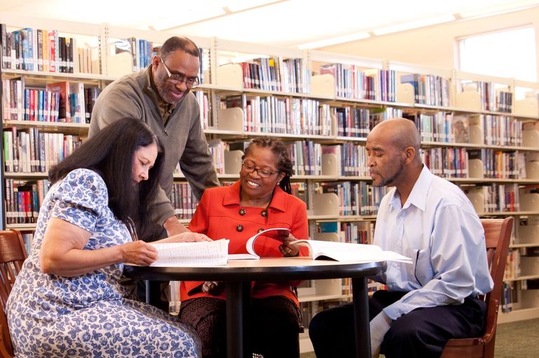 Group of four adults studying together.