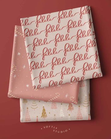 Three folded fabrics featuring festive scripts, candy canes, and holiday trees in soft colours.