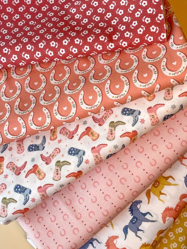 Selection of cowgirl fabrics featuring boots, horseshoes, and florals.