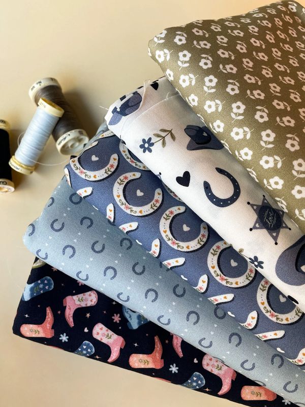 Western cowgirl fabric bundle with horseshoes, boots, and flowers in blue tones.