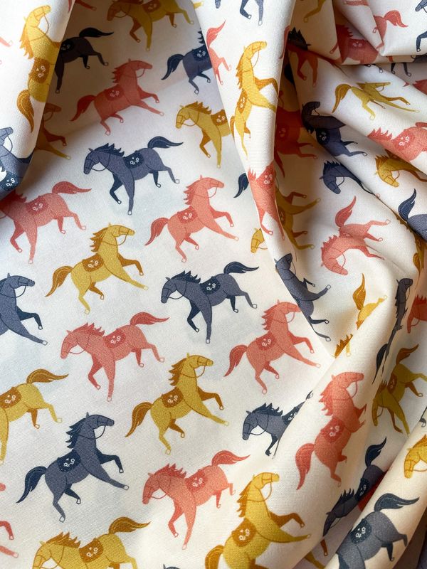 Western fabric with colourful horses in mustard, coral, and navy from Pony Luck.