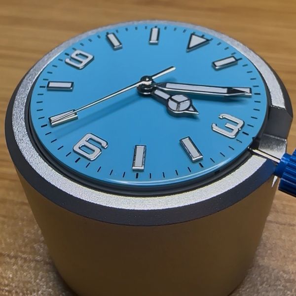 Close-up of a blue watch face with silver hands and markers.