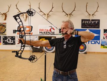 Employee demonstrating bow shooting form