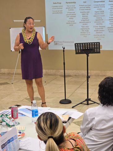 Woman giving presentation in front of seated audience.