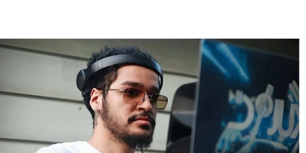 Man with headphones and glasses DJing with a laptop.