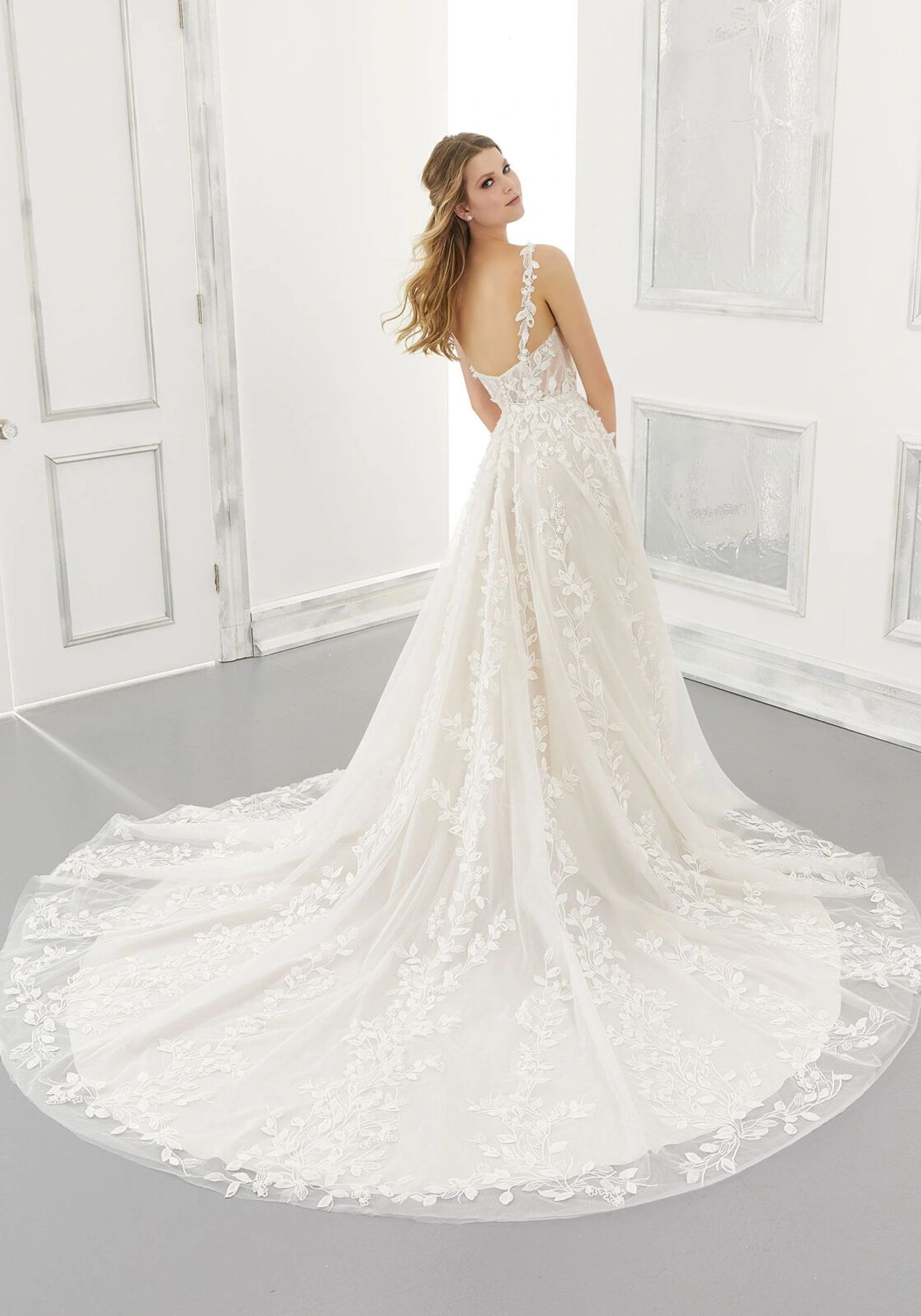 Whimsical wedding gown by Morilee. Adelaide features floral and leafy appliqués. Delicate draping