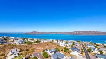 Coastal town with blue waters and clear skies under bright sunlight.