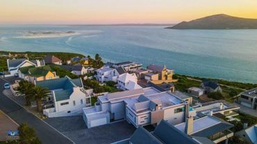 Coastal residential neighborhood with modern houses at sunset.
