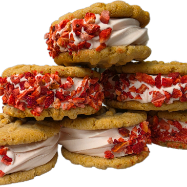 Stack of ice cream cookie sandwiches with strawberry pieces.