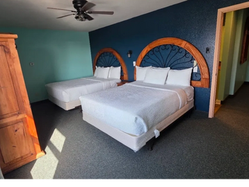 Cozy motel room with two beds and wooden headboards.