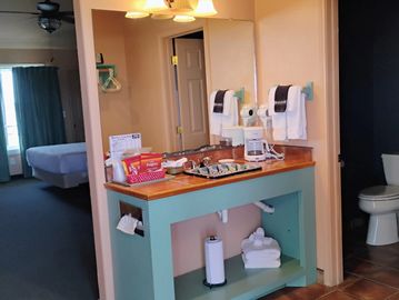 A kitchenette area with coffee supplies and towels in a room.